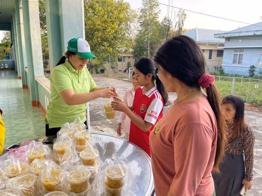 Chị Nguyễn Thị Tâm (bìa trái) cẩn thận đóng hũ từng suất ăn sáng trước khi phát cho bệnh nhân. Ảnh: Vũ Chi