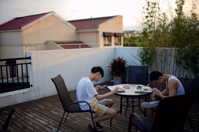 Trẻ em Thượng Hải sử dụng điện thoại trong quán cà phê. Ảnh: Reuters