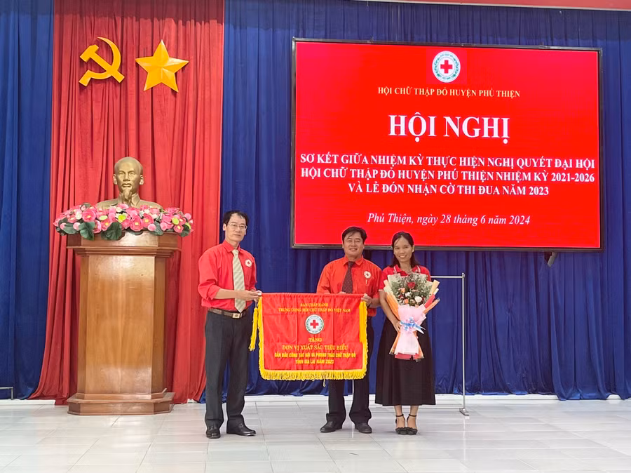 Được sự ủy quyền của Trung ương Hội Chữ thập đỏ Việt Nam, Chủ tịch Hội Chữ thập đỏ tỉnh Dương Đình Diện trao Cờ thi đua cho Hội Chữ thập đỏ huyện Phú Thiện. Ảnh: Vũ Chi