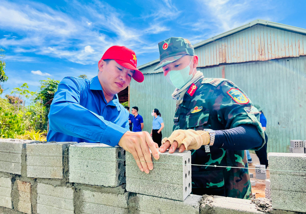 Bí thư Thành Đoàn Pleiku Thái Giang Nam (bìa trái) góp công xây nhà cho hộ nghèo ở làng D )(xã Gào). Ảnh M.N bi-thu-thanh-doan-pleiku-thai-giang-nam-bia-trai-gop-cong-xay-nha-cho-ho-ngheo-o-lang-d-xa-gao-anh-mn.jpg
