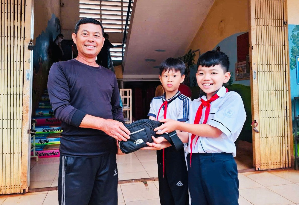 2 học sinh Trường Tiểu học Nguyễn Văn Trỗi (xã Ia Phang, huyện Chư Pưh) trả lại túi xách cho ông Nguyễn Đông. Ảnh: M.N 2-hoc-sinh-truong-tieu-hoc-nguyen-van-troi-xa-ia-phang-huyen-chu-puh-tra-lai-tui-xach-cho-ong-nguyen-dong-jpg.jpg