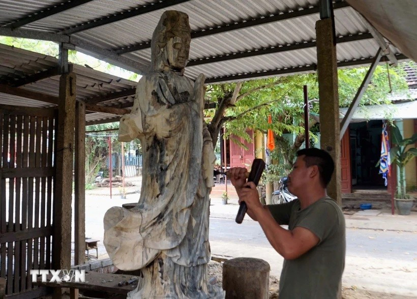 Nghệ nhân làng mộc truyền thống Kim Bồng đục, chạm các tác phẩm gỗ mỹ nghệ. (Ảnh: Trịnh Bang Nhiệm/TTXVN) untitled-4909.jpg