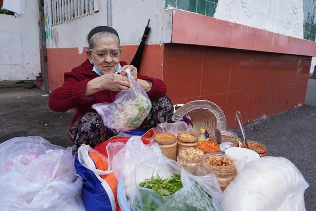 Cụ bà hiếu khách, tay vừa trộn bánh vừa kể chuyện Cụ bà hiếu khách, tay vừa trộn bánh vừa kể chuyện