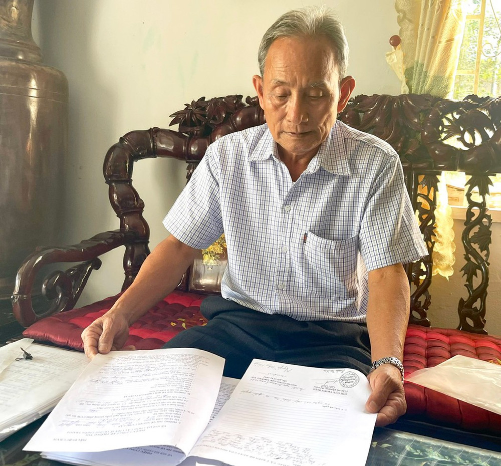 Ông Lý Văn Mười kiểm tra thông tin về hài cốt liệt sĩ đã thu thập. Ảnh: P.D 1-8678.jpg