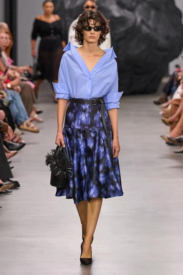 Michael Kors đã tạo ra những bộ trang phục mang phong cách nữ tính nhờ sự hiện diện của váy midi họa tiết hoa và túi rơm Michael Kors đã tạo ra những bộ trang phục mang phong cách nữ tính nhờ sự hiện diện của váy midi họa tiết hoa và túi rơm