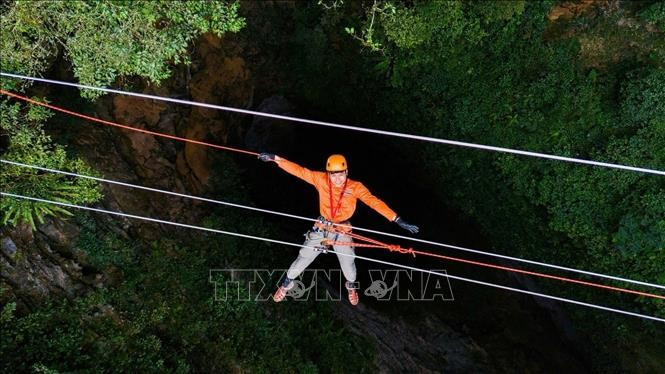 Du khách trải nghiệm đu dây qua hố sụt Ác Mộng. Ảnh: TTXVN phát Du khách trải nghiệm đu dây qua hố sụt Ác Mộng. Ảnh: TTXVN phát