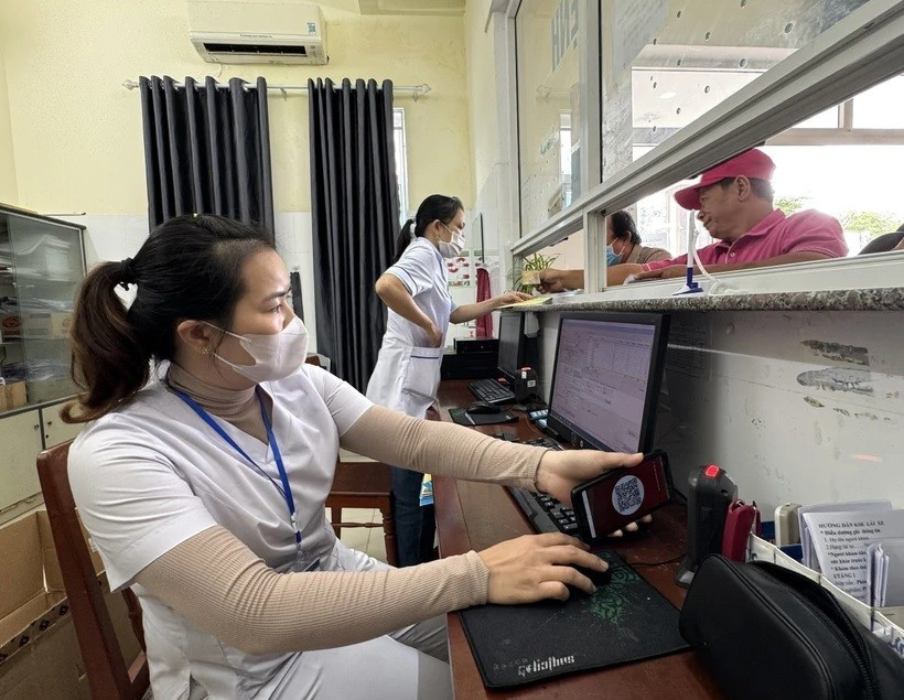 Nhân viên y tế quét mã lấy số và đăng ký khám bệnh tại quầy phát số tự động. Ảnh: Internet untitled-6202.jpg