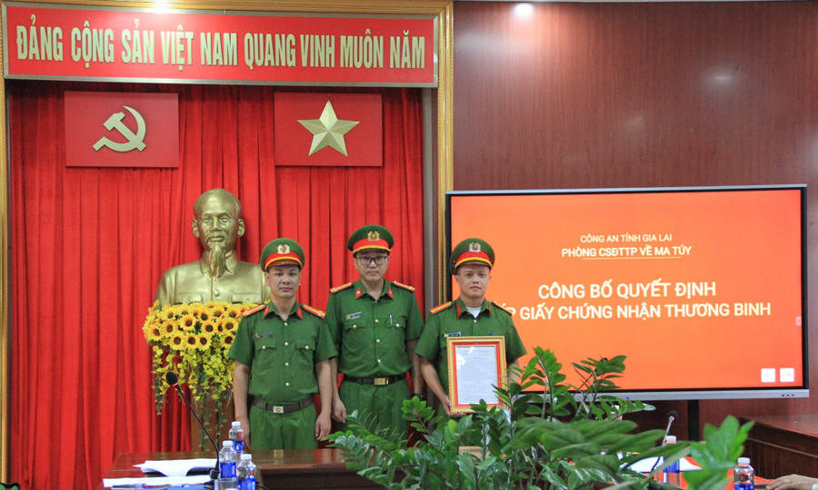Thượng tá Nguyễn Đức Hoàng-Trưởng Phòng Cảnh sát điều tra tội phạm về ma túy (giữa) trao quyết định công nhận thương binh cho Thiếu tá Nguyễn Văn Hưng (bìa phải). Ảnh: Hoàng Hoài img-5776.jpg
