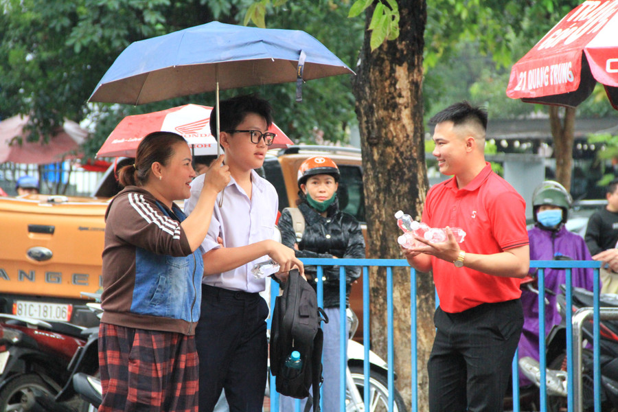 Thời tiết không thuận lợi vì mưa lớn nhưng nhiều phụ huynh vẫn tranh thủ đưa con đến điểm thi sớm và dành nhiều lời động viên, chúc con thi tốt. Ảnh: Hoàng Hoài img-5886.jpg