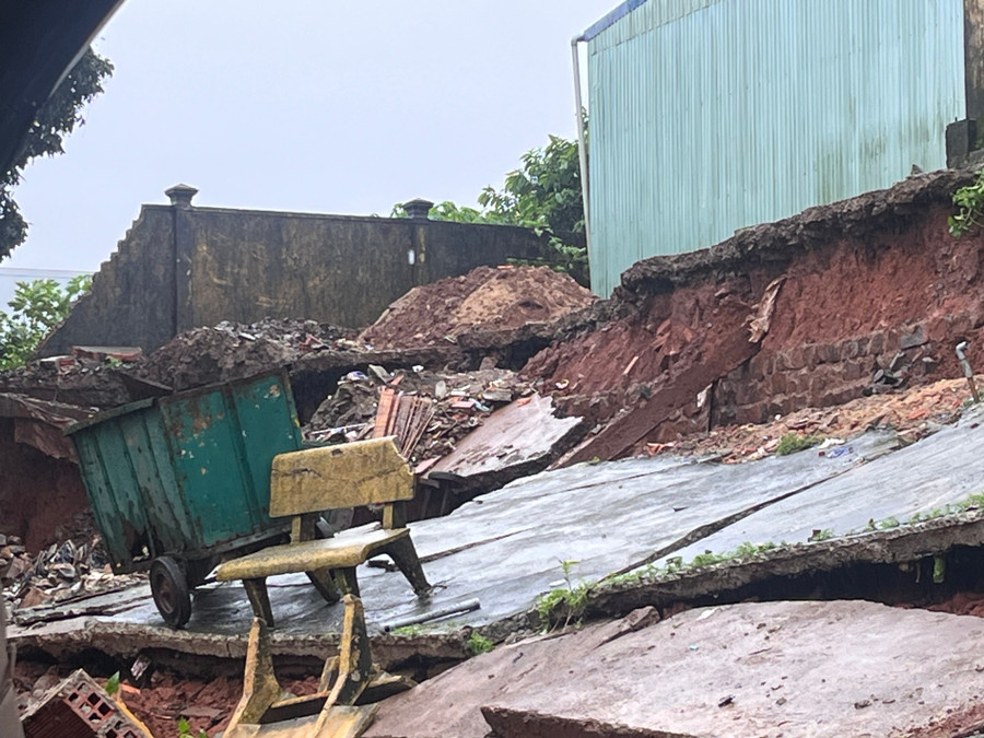 Phần tường rào đổ sập kéo theo nền bê tông bị rạn nứt, sạt lở, đổ ụp xuống nhà dân phía dưới. Ảnh: H.H img-6752.jpg