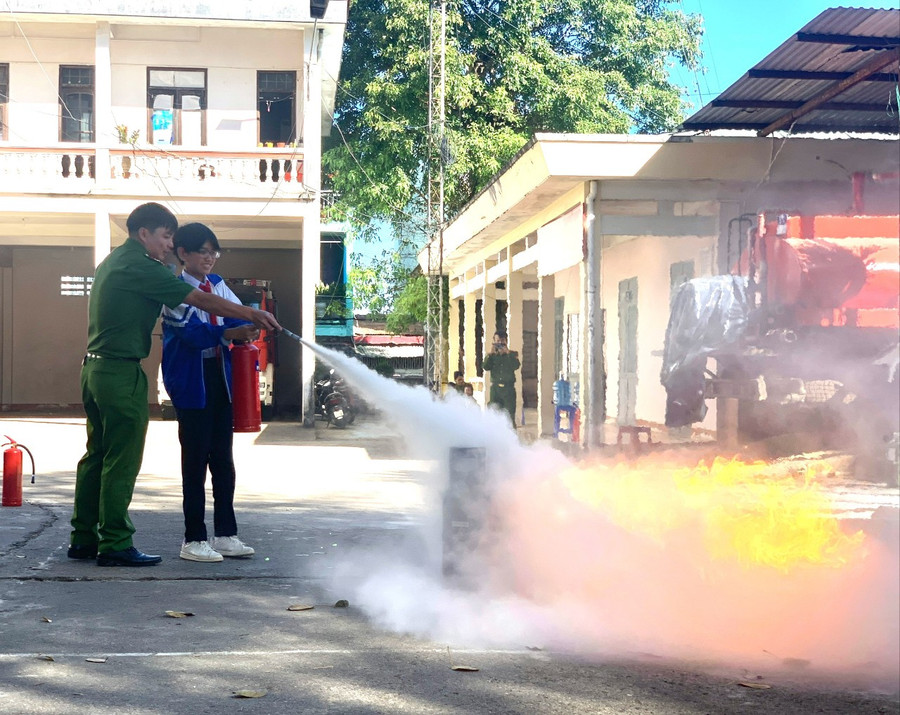 Học sinh Trường THCS Trần Phú (phường Trà Bá, TP. Pleiku) thực hành sử dụng bình chữa cháy xách tay để dập tắt đám cháy do rò rỉ khí gas. Ảnh: R'Ô HOK