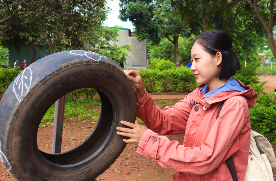 Lê Ánh Thùy Trang-Trưởng nhóm Flowers tự tay trang trí những lốp xe cũ. Ảnh: Lạc Hà