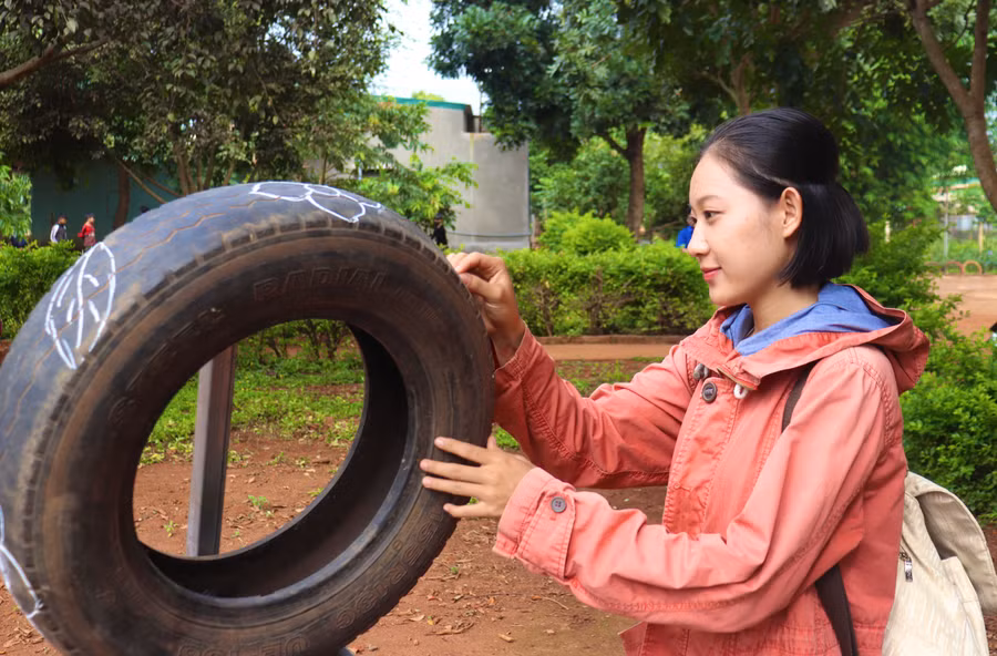Lê Ánh Thùy Trang-Trưởng nhóm Flowers tự tay trang trí những lốp xe cũ. Ảnh: Lạc Hà