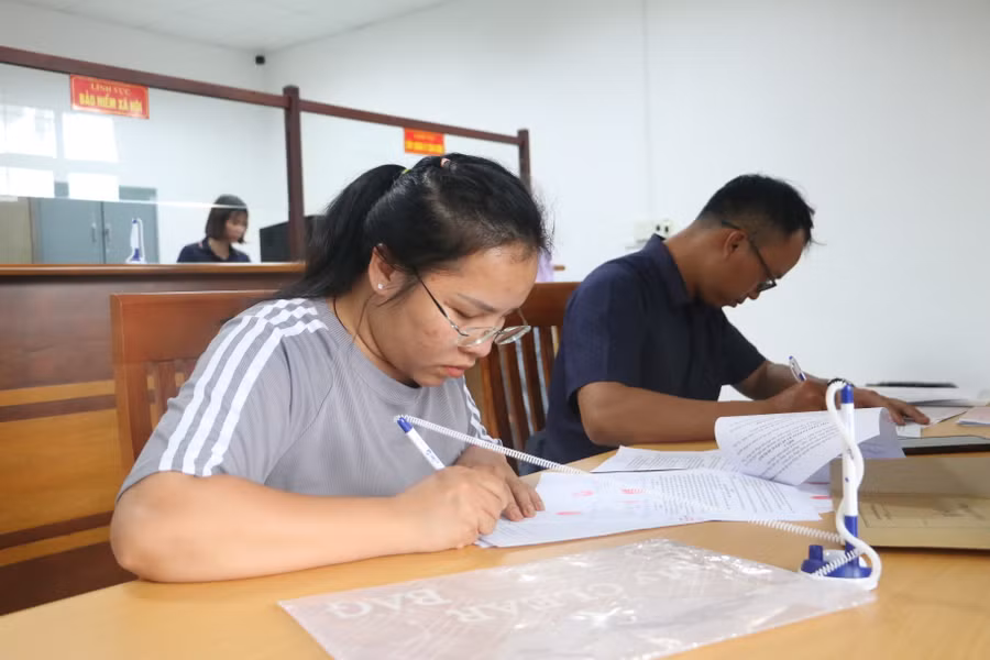 Chị Nguyễn Thị Hà (bìa trái) làm thủ tục chuyển nhượng đất tại UBND xã Nghĩa Hưng (huyện Chư Păh). Ảnh: Lạc Hà