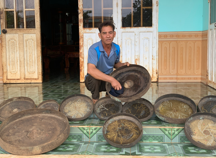 Ông Siu Yê lau chùi cồng chiêng của gia đình mình. Ảnh: R.H