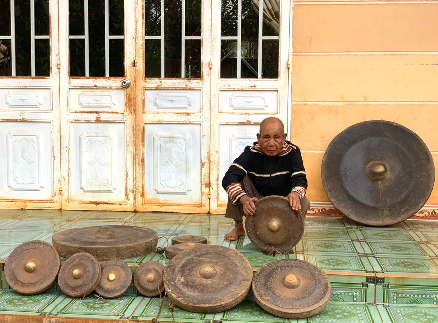 Ông Puih Bé bày biện một số cồng chiêng quý của gia đình trước hiên nhà để cùng chiêm ngưỡng. Ảnh: R.H