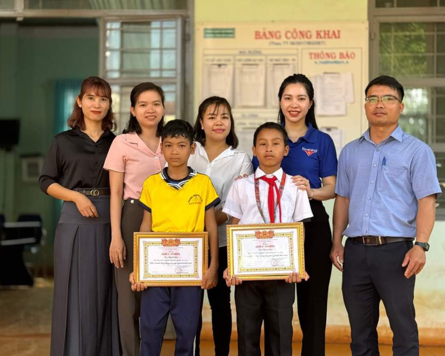 Hội Đồng đội huyện Chư Prông tặng giấy khen gương người tốt, việc tốt có hành động dũng cảm cứu người bị đuối nước cho em Kpuih Sân và Kpuih Dấu (áo vàng). Ảnh: Hội Đồng đội huyện Chư Prông