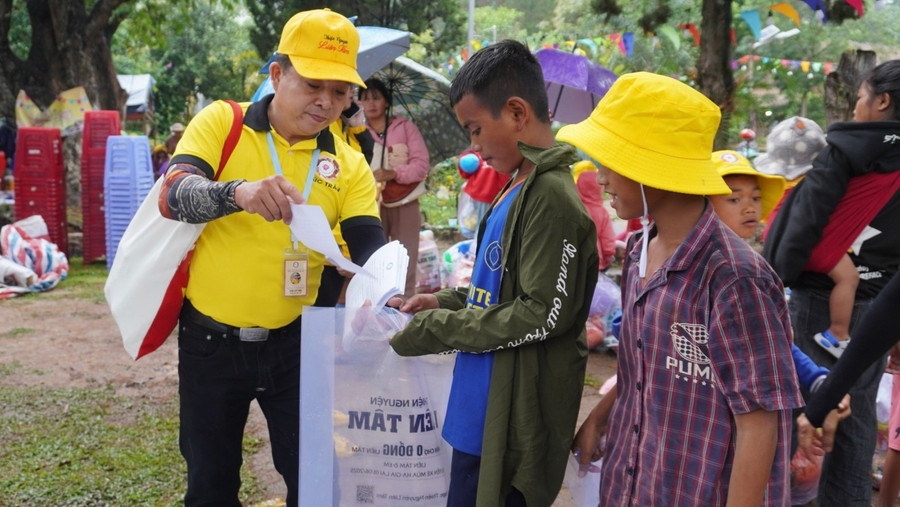 Các tình nguyện viên tận tình phát phiếu và túi đựng giúp các em nhỏ thuận tiện lựa chọn và nhận những phần quà. Ảnh: Chu Hằng dsc01910.jpg