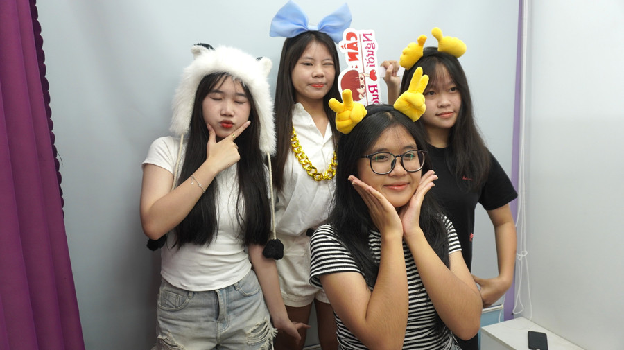 Bạn Phan Trịnh Tâm Như (đội mũ trắng) cùng nhóm bạn chụp ảnh photobooth. Ảnh: Chu Hằng sss.jpg