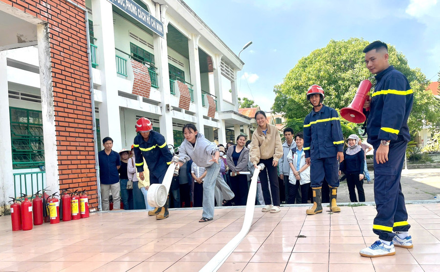 Lực lượng chức năng tuyên truyền phổ biến kiến thức về PCCC cho cán bộ, giáo viên, học sinh Trường THPT Nguyễn Trãi. Ảnh: Ngọc Minh huong-dan-hoc-sinh-truong-thpt-nguyen-trai-thi-xa-an-khe-cach-su-dung-thiet-bi-cuon-voi-phun-nuoc-chua-chay-anh-ngoc-minh.jpg