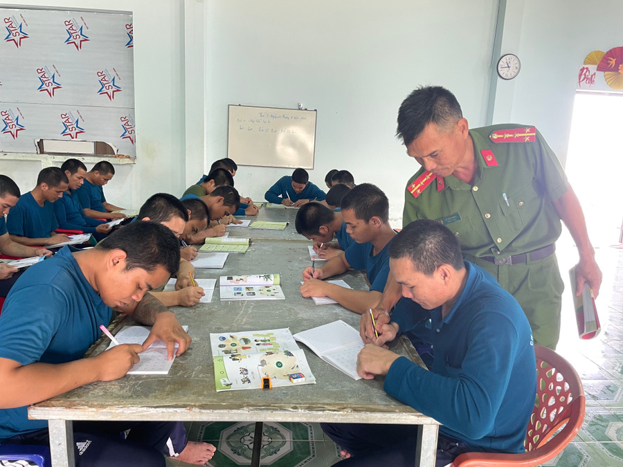Các cán bộ Công an tận tình kèm cặp, uốn nắn cho học viên từng nét chữ. Ảnh: Văn Ngọc cac-can-bo-cong-an-tan-tinh-kem-cap-cho-cac-hoc-vien-tung-net-chu-anh-van-ngoc.jpg