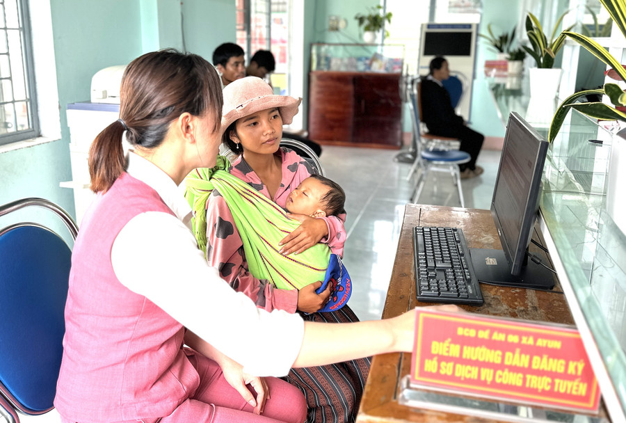 Chị Nhor (người bế cháu bé, làng Kon Brung) nghe cán bộ Trung tâm Phục vụ hành chính công xã Ayun hướng dẫn thủ tục khai sinh trực tuyến cho con. Ảnh: Hà Duy 2-8560.jpg