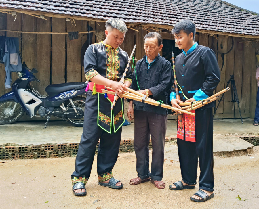 Ông Lý Văn Tính (ở giữa) hướng dẫn học viên sử dụng khèn. Ảnh: Đ.L ong-ly-van-tinh-dung-giua-dang-huong-dan-hoc-tro-su-dung-khen-anh-dong-lai-1.jpg