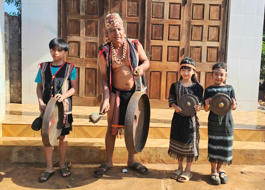 Nghệ nhân Ayó (làng Piơm, xã Đak Đoa) truyền dạy cho các cháu mình cách đánh cồng chiêng. Ảnh: R.H 1-3.jpg