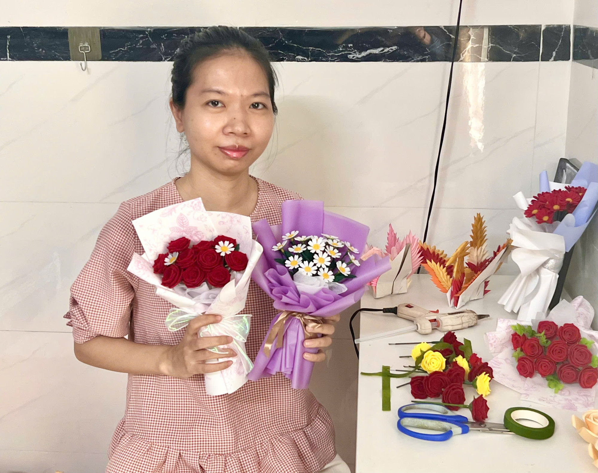 Chị Nga cùng những bó hoa nỉ handmade rực rỡ. Ảnh: D.L handmade-chi-nga.jpg