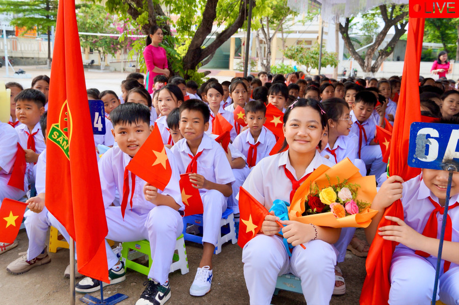 Em Nguyễn Hoàng Bảo An (lớp 6A3, cầm hoa) háo hức tại lễ khai giảng cùng các bạn. Ảnh: Nguyễn Muội Em Nguyễn Hoàng Bảo An (lớp 6A3, cầm hoa) háo hức tại lễ khai giảng cùng các bạn. Ảnh: Nguyễn Muội