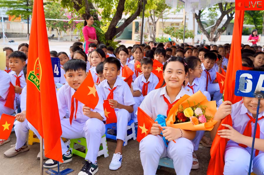 Em Nguyễn Hoàng Bảo An (lớp 6A3, cầm hoa) háo hức tại lễ khai giảng cùng các bạn. Ảnh: Nguyễn Muội