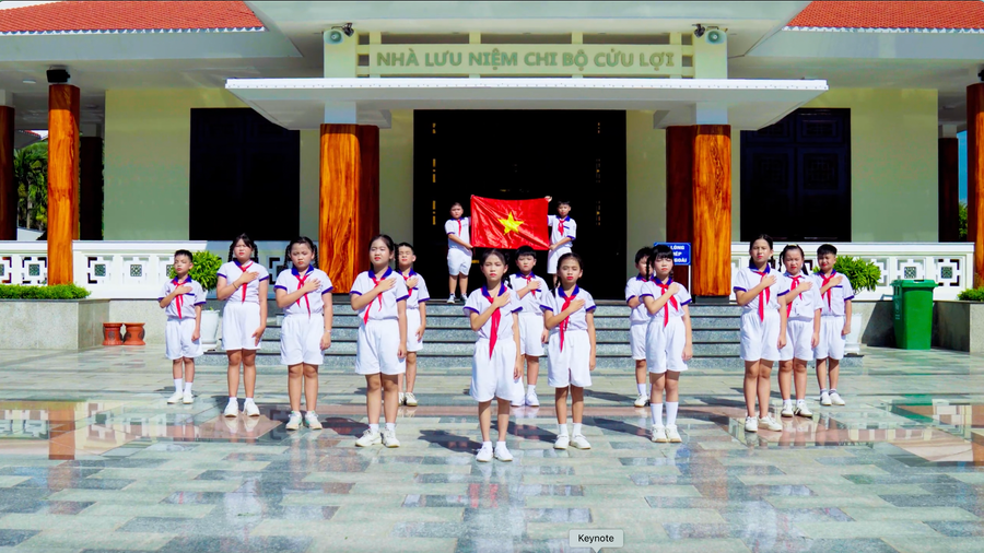 Thiếu nhi Trường Tiểu học số 1 Hoài Châu Bắc ghi hình tiết mục vào một ngày đầy nắng của tháng 6.2025. Ảnh: Cắt ra từ video 2-hat-quoc-ca-dia-chi-do.png