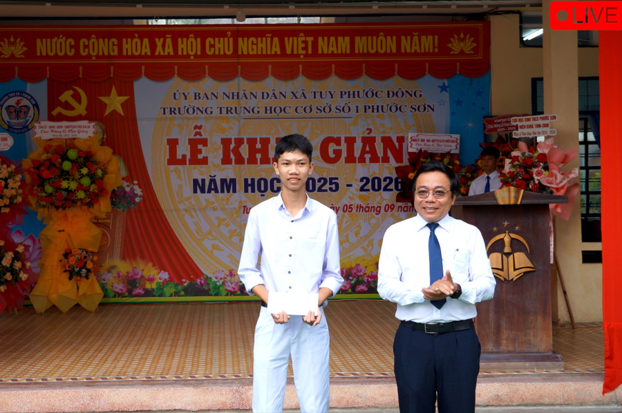 Em Nguyễn Phan Thành Hiếu được nhà trường vinh danh và tặng quà tại lễ khai giảng. Ảnh: Nguyễn Muội dsc04022-4506.jpg