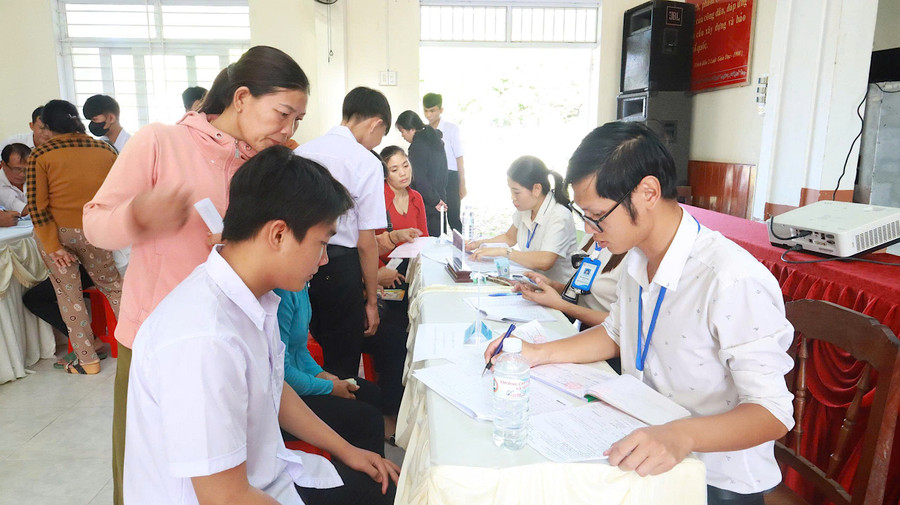 Phụ huynh và học sinh tìm hiểu thông tin, làm thủ tục nhập học. Ảnh: ĐVCC 2.jpg