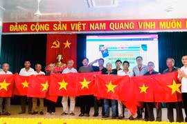 Lãnh đạo Sở Ngoại vụ Gia Lai tặng cờ Tổ quốc cho ngư dân xã Cát Tiến. Ảnh: Phi Long