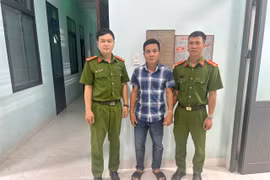 Đối tượng truy nã Phan Trần Tiến (giữa) tại cơ quan Công an.