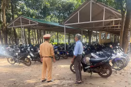 Lực lượng chức năng kiểm tra công tác quản lý, trông giữ phương tiện tại bãi giữ xe của Trường THPT Trần Hưng Đạo.