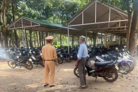 Lực lượng chức năng kiểm tra công tác quản lý, trông giữ phương tiện tại bãi giữ xe của Trường THPT Trần Hưng Đạo.