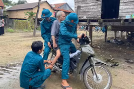 Lực lượng dân quân xã Ia Tul hỗ trợ đưa người già yếu đến nơi sơ tán an toàn. Ảnh: Vũ Chi