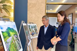 Các đại biểu ngắm một số tác phẩm nhiếp ảnh được trưng bày tại buổi lễ. Ảnh: Lam Nguyên