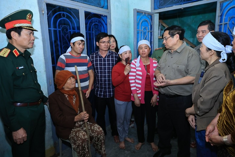 Thủ tướng Phạm Minh Chính thăm, động viên thân nhân gia đình có người bị thiệt mạng do mưa lũ - Ảnh: VGP/Nhật Bắc