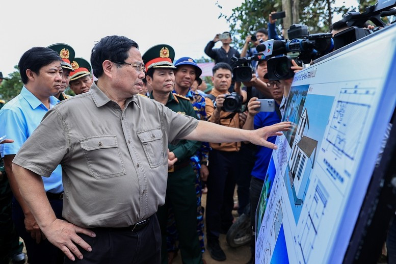 Thủ tướng Phạm Minh Chính nghe báo cáo về thiết kế nhà chống lũ - Ảnh: VGP/Nhật Bắc