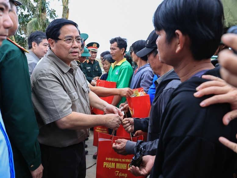 Thủ tướng Phạm Minh Chính động viên, tặng quà hỗ trợ bà con nhân dân thôn Phú Hữu, xã Hòa Thịnh - Ảnh: VGP/Nhật Bắc