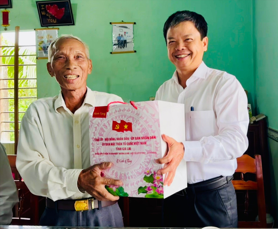 Đồng chí Nguyễn Hữu Quế (bên phải) tặng quà ông Lê Văn Dần (thương binh, ở xã Bình An). Ảnh: Trương Trang anh-1-dong-chi-nguyen-huu-que-tham-tang-qua-tai-gia-dinh-ong-le-van-dan-thuong-binh-o-xa-binh-an-1482.jpg
