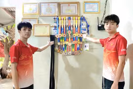 Trần Võ Tuấn Kiệt (bìa trái) và Trần Võ Trí Tín giới thiệu thành tích thi đấu môn Karate của mình. Ảnh: R'Ô HOK