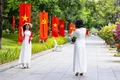 Người dân, du khách tranh thủ check in với cờ đỏ sao vàng trên đường Nguyễn Tất Thành.