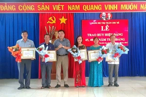 Bí thư Huyện ủy Chư Sê Lý Anh Sang trao tặng Huy hiệu 30 năm tuổi Đảng cho các đảng viên thuộc Đảng bộ thị trấn Chư Sê. Ảnh: H.V