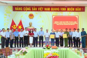 Phó Chủ tịch UBND tỉnh Nguyễn Tuấn Anh (thứ 10 từ phải sang) tặng quà của Tỉnh ủy, HĐND, UBND, Ủy ban MTTQ Việt Nam tỉnh cho lãnh đạo và Công an phường Hoài Nhơn Tây. Ảnh: Phi Long