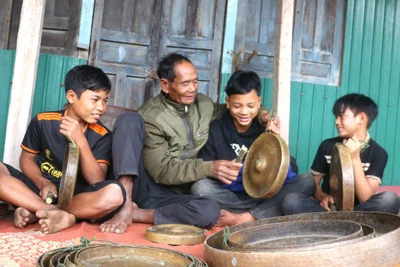 Già làng Đinh Đuk (làng Tờ Nùng 1, xã Ya Ma) ân cần hướng dẫn các em nhỏ cách diễn tấu cồng chiêng. Ảnh: N.M