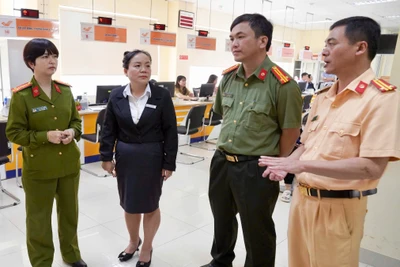Thượng tá Ksor H’Bơ Khắp-Phó Giám đốc Công an tỉnh (bìa trái) kiểm tra thủ tục cấp, đổi giấy phép lái xe tại Trung tâm Phục vụ hành chính công tỉnh. Ảnh: NÔNG HÒA